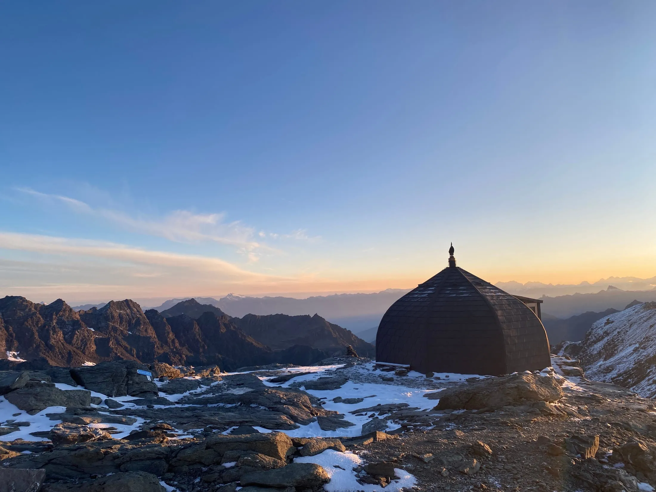The dark dome hut above the rocky basin at dawn.