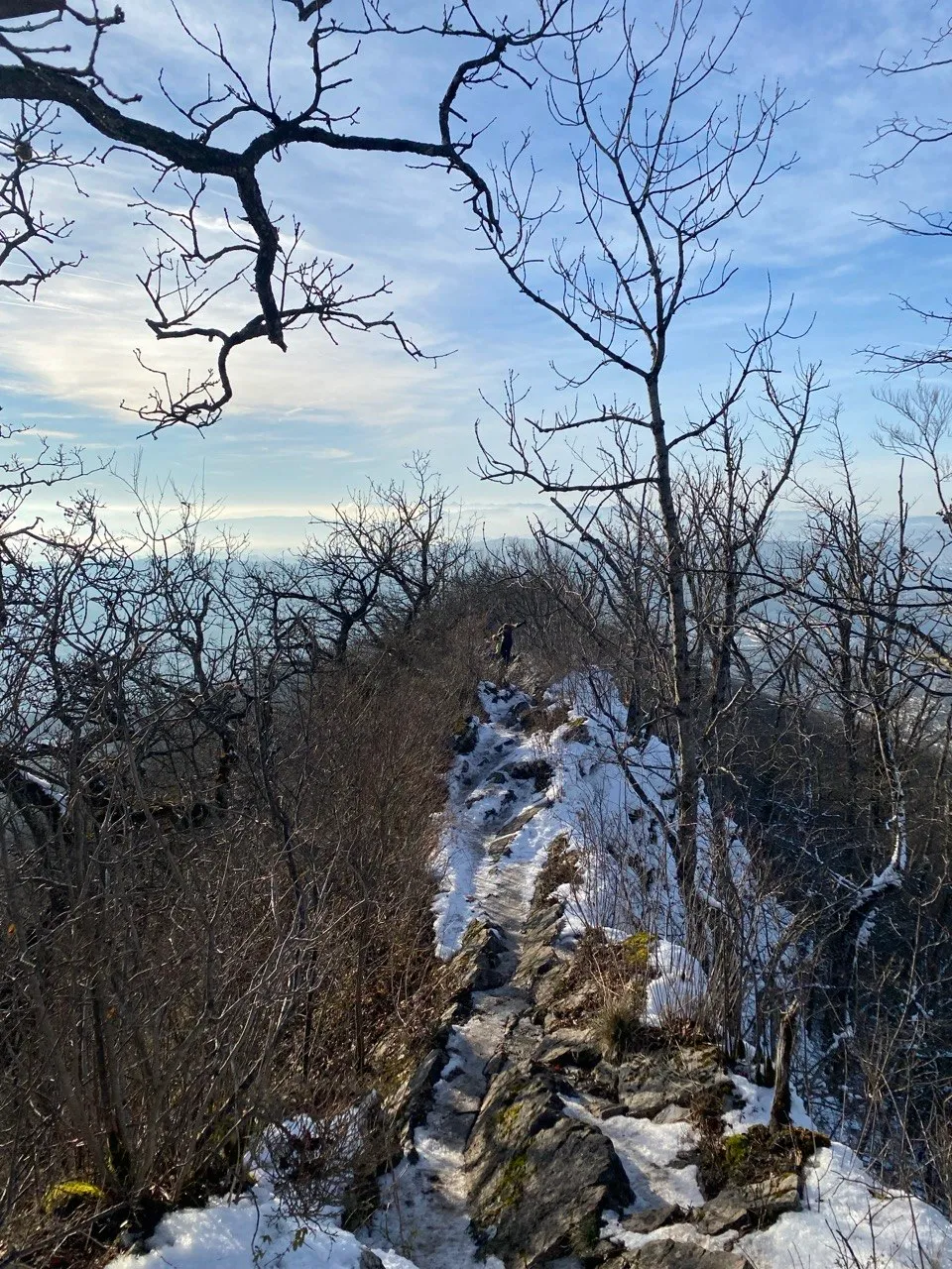 Narrow, partly snow-covered ridge path on the Lägerngrat, hiker in the distance.