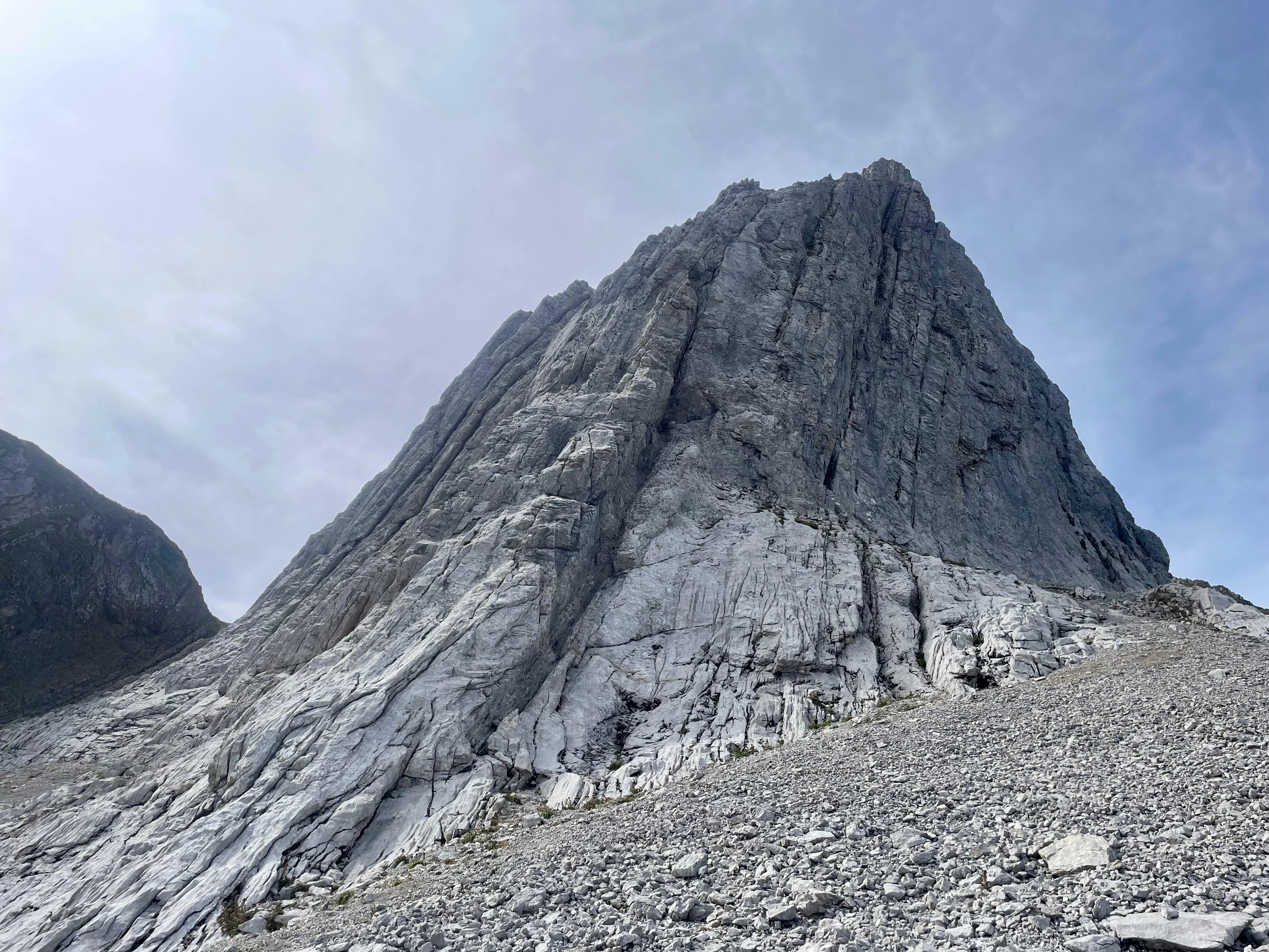 The east face of the Altmann — a massive grey limestone pyramid rising above pale scree.