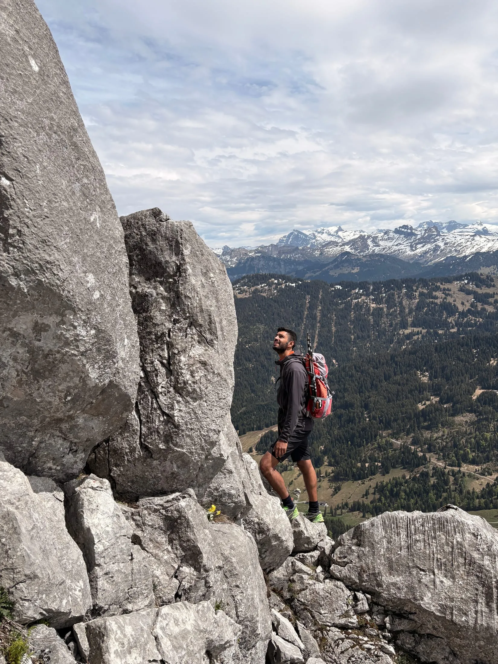 A climber works up the short rock step onto the Chli Mythe, pack on and helmet clipped.