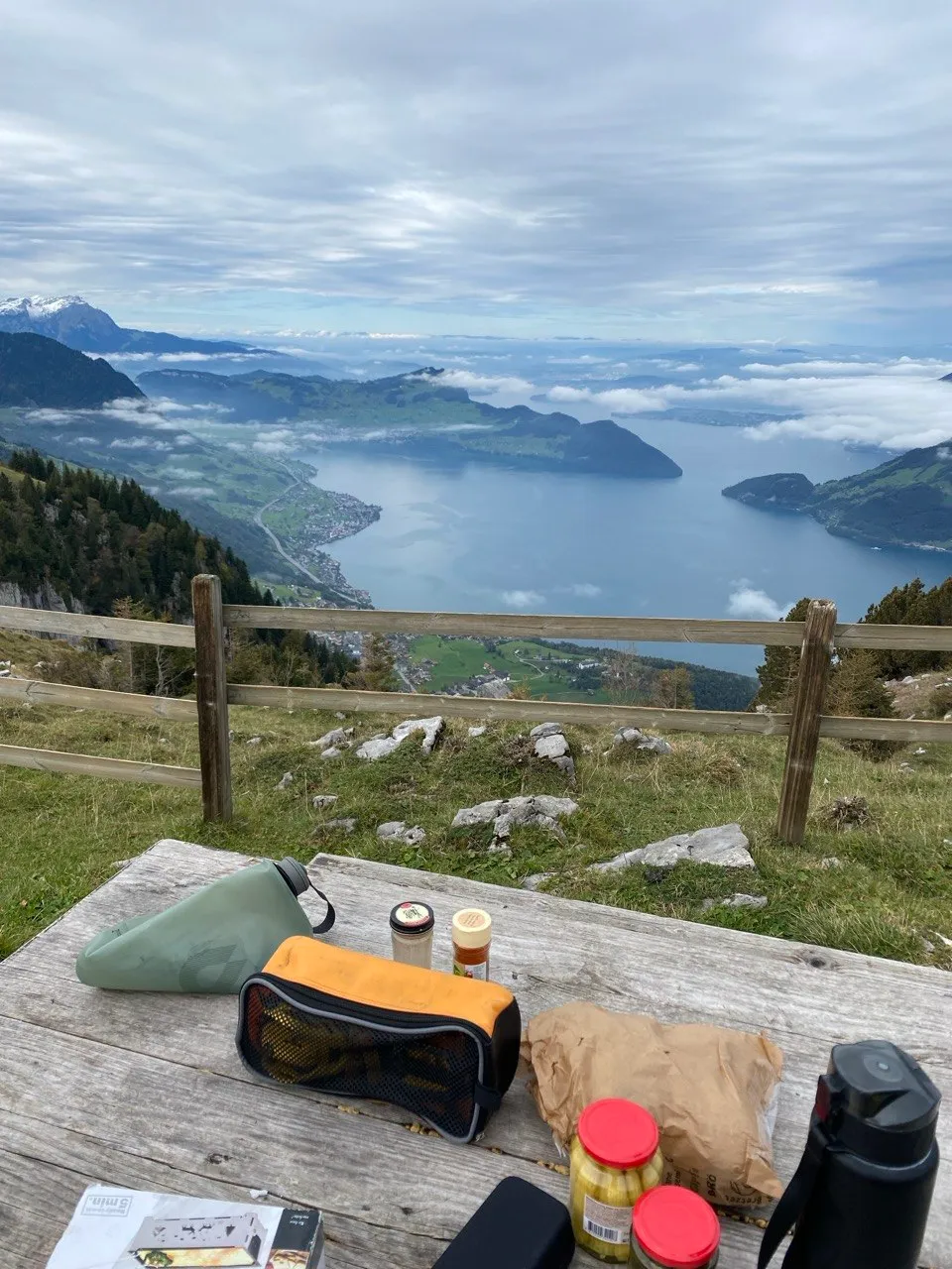 Trail snacks laid out at a rest stop, fence and lake in the background.