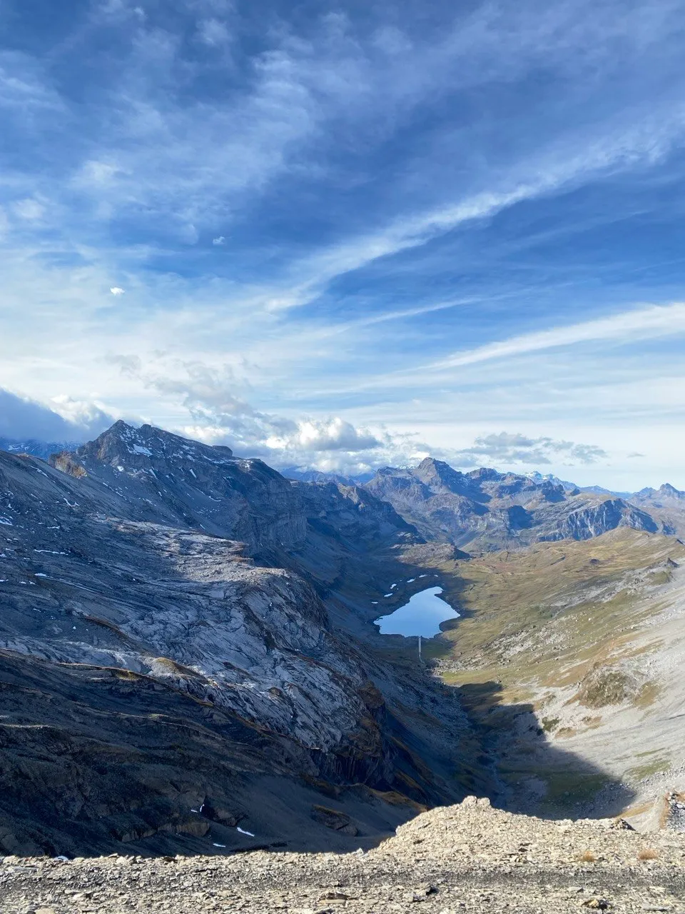 Turquoise mountain lake nestled between rugged ridges, panoramic view.