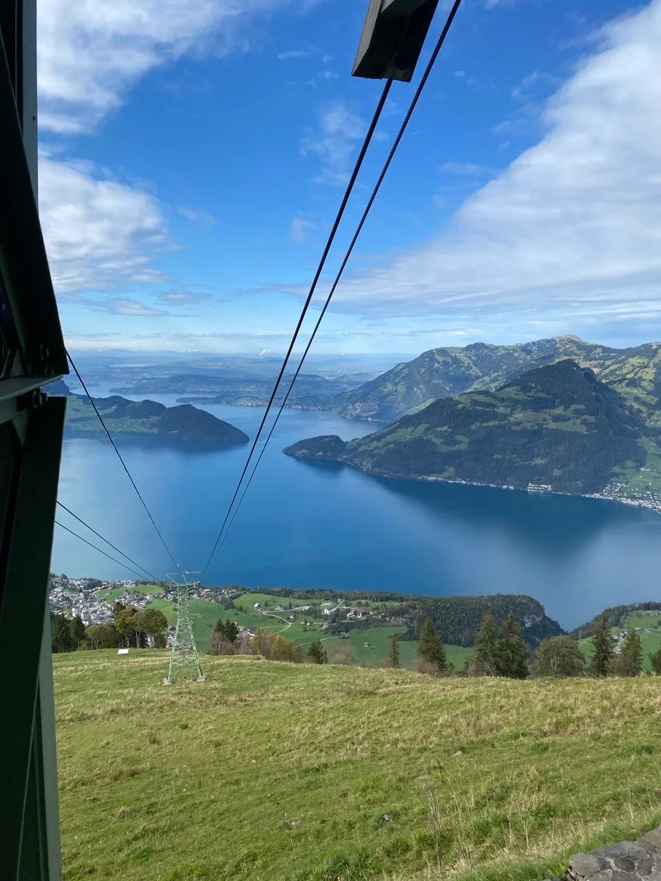 View from inside the cable car over the lake, cables in the foreground.