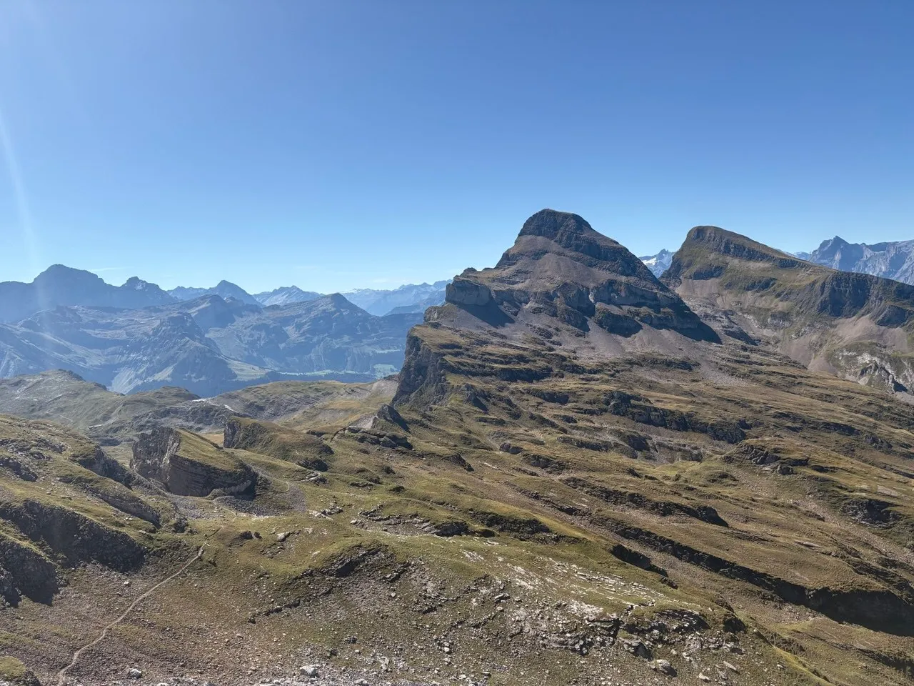 The pyramid-shaped Chaiserstock rising above green-grey slopes, with layered mountain ranges behind.