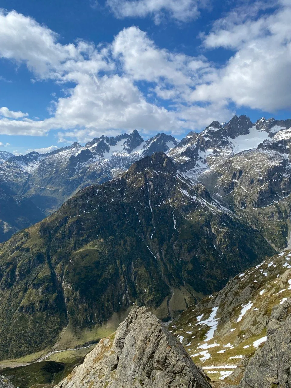 A jagged panorama of snow-streaked peaks under a partly cloudy sky.