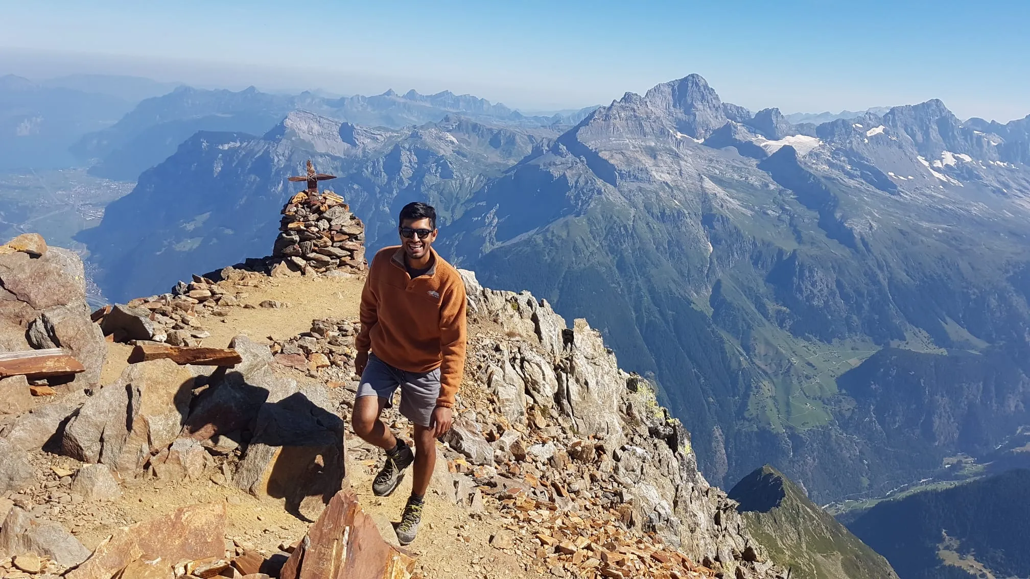 Resting at the summit cairn of the Bristen with a vast all-round panorama across the Uri Alps.