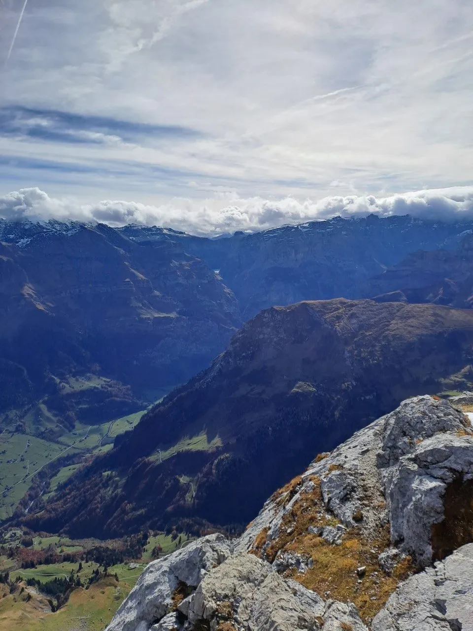 Summit view over layered mountain ridges and clouds in the valley.