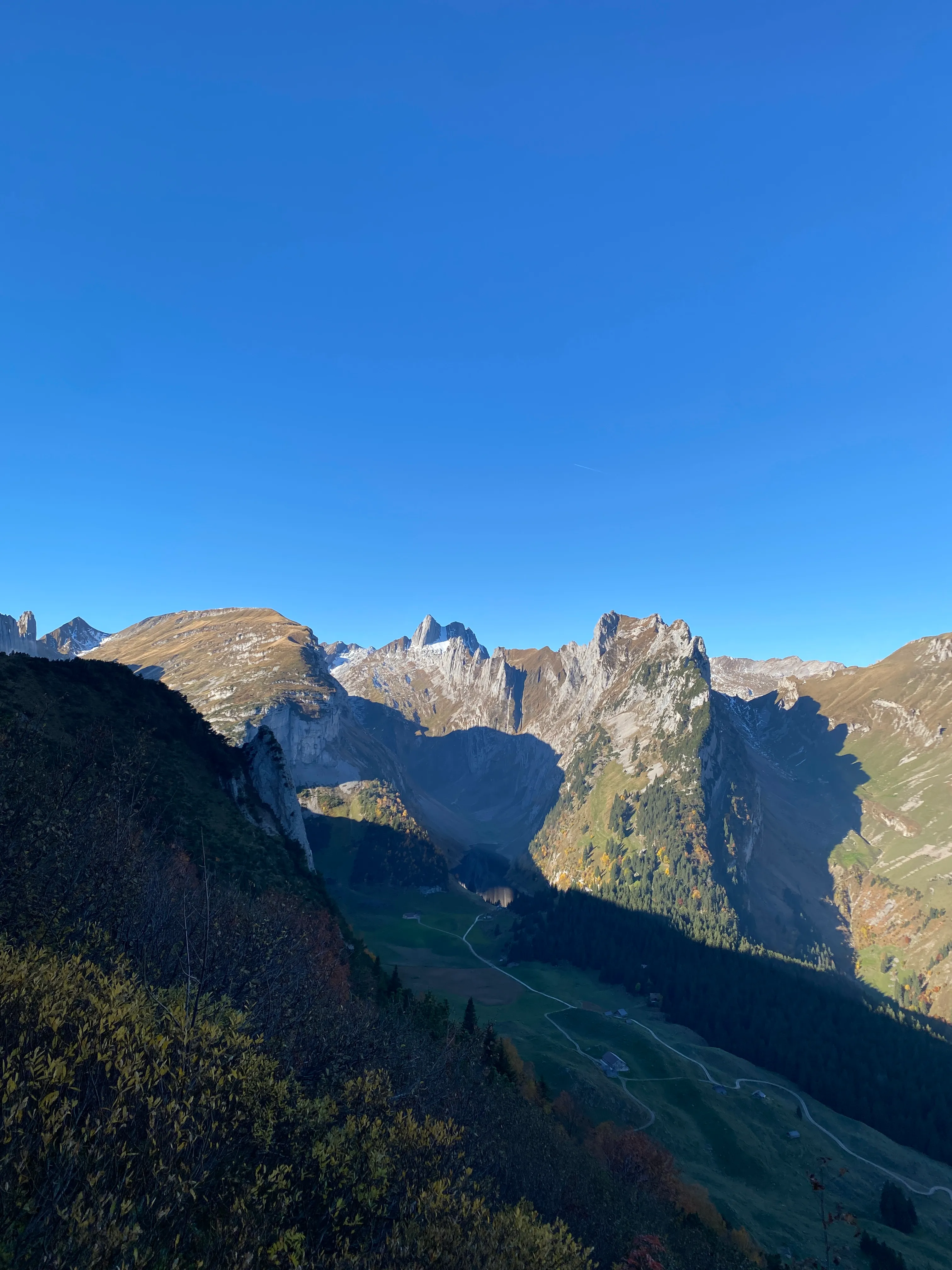 Looking down into the valley with a small mountain lake and the jagged Kreuzberge in the morning light.