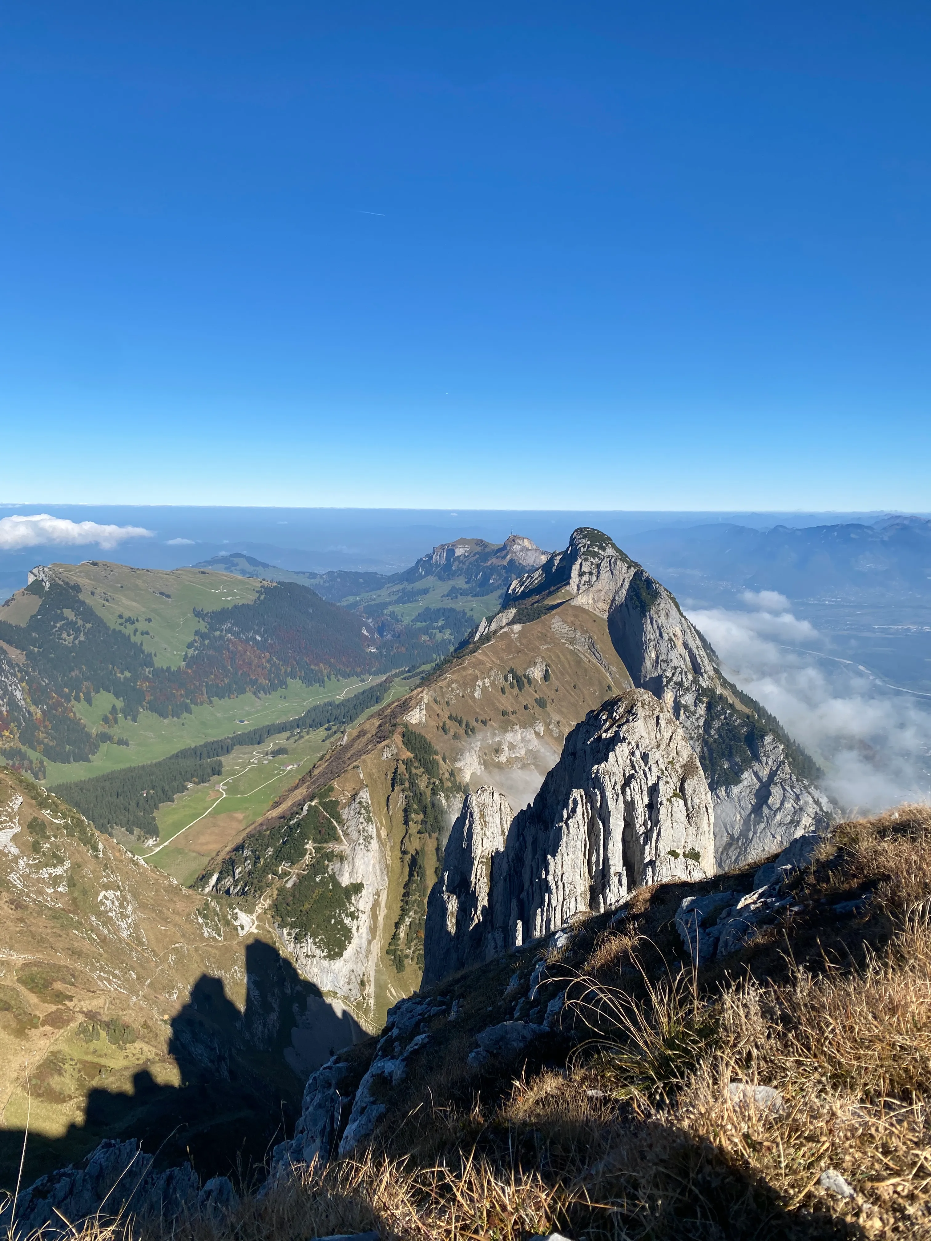 The sweeping pale limestone Kreuzberg ridge, an autumn valley and rising clouds beyond.