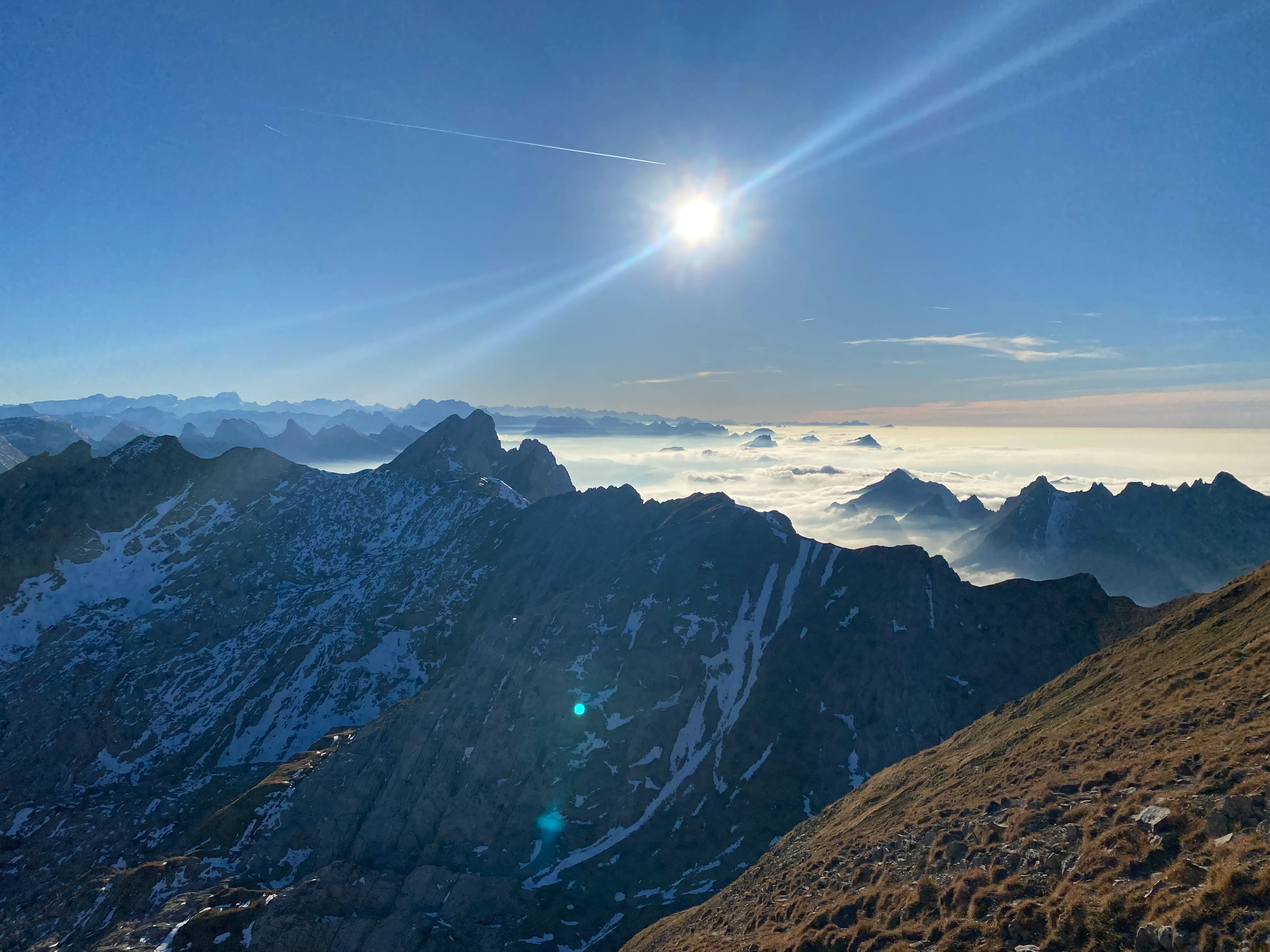 The low sun over a sea of fog with countless ridges poking through.
