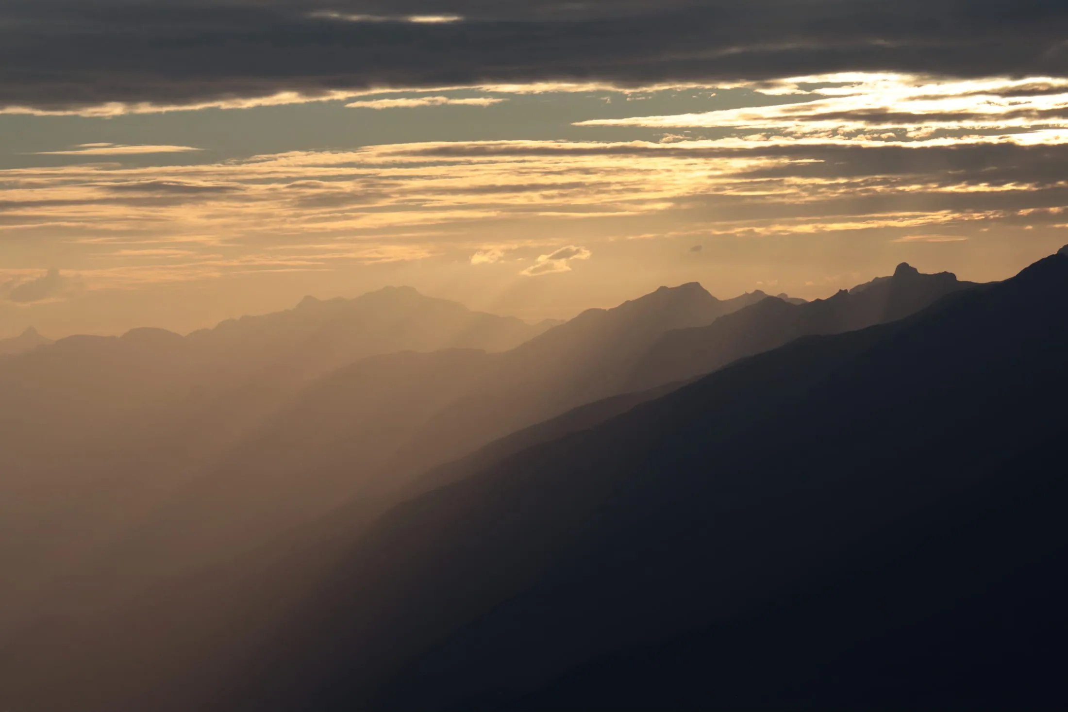Layered mountain silhouettes in soft early light.