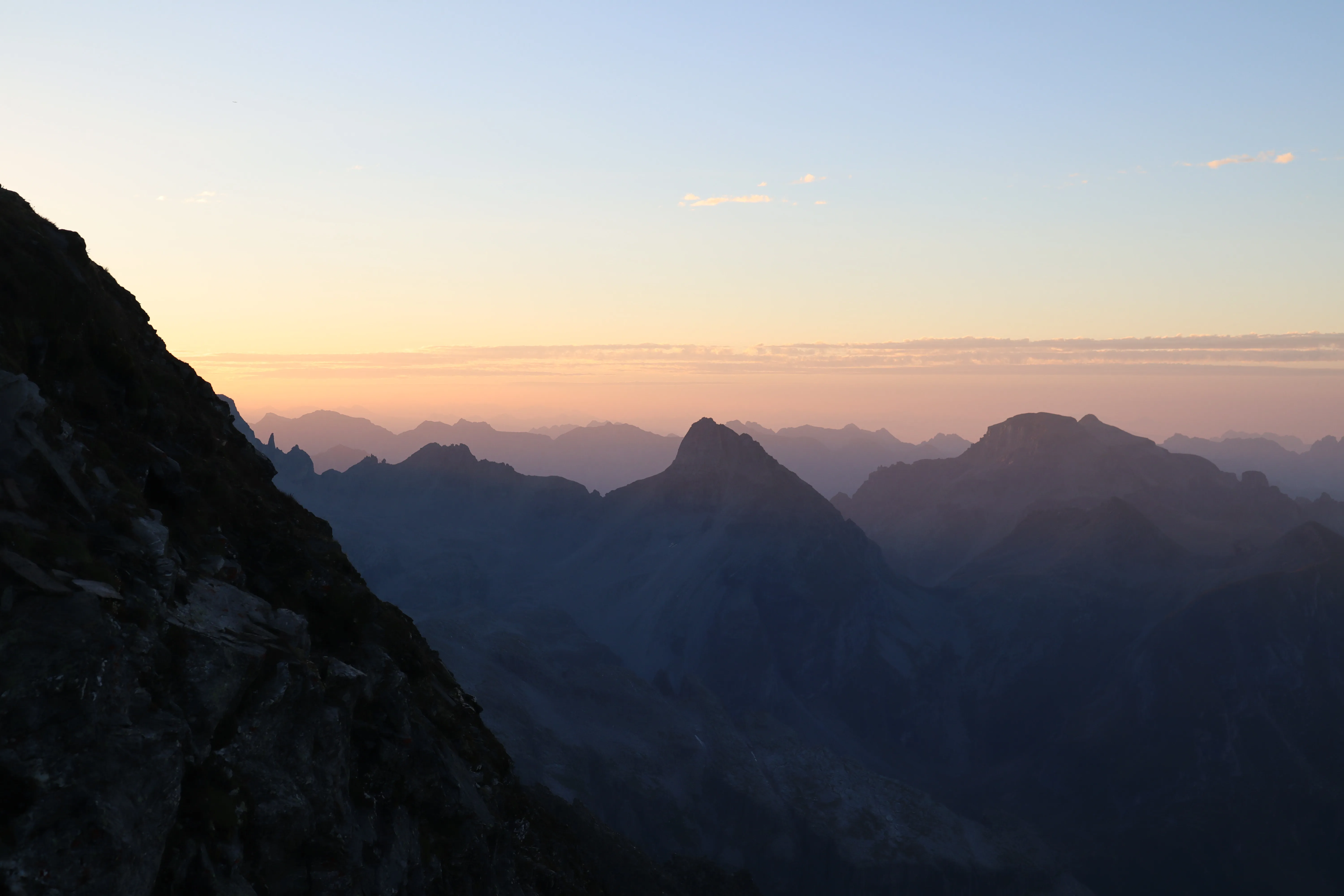 Dawn light spreading across a sea of jagged peaks.