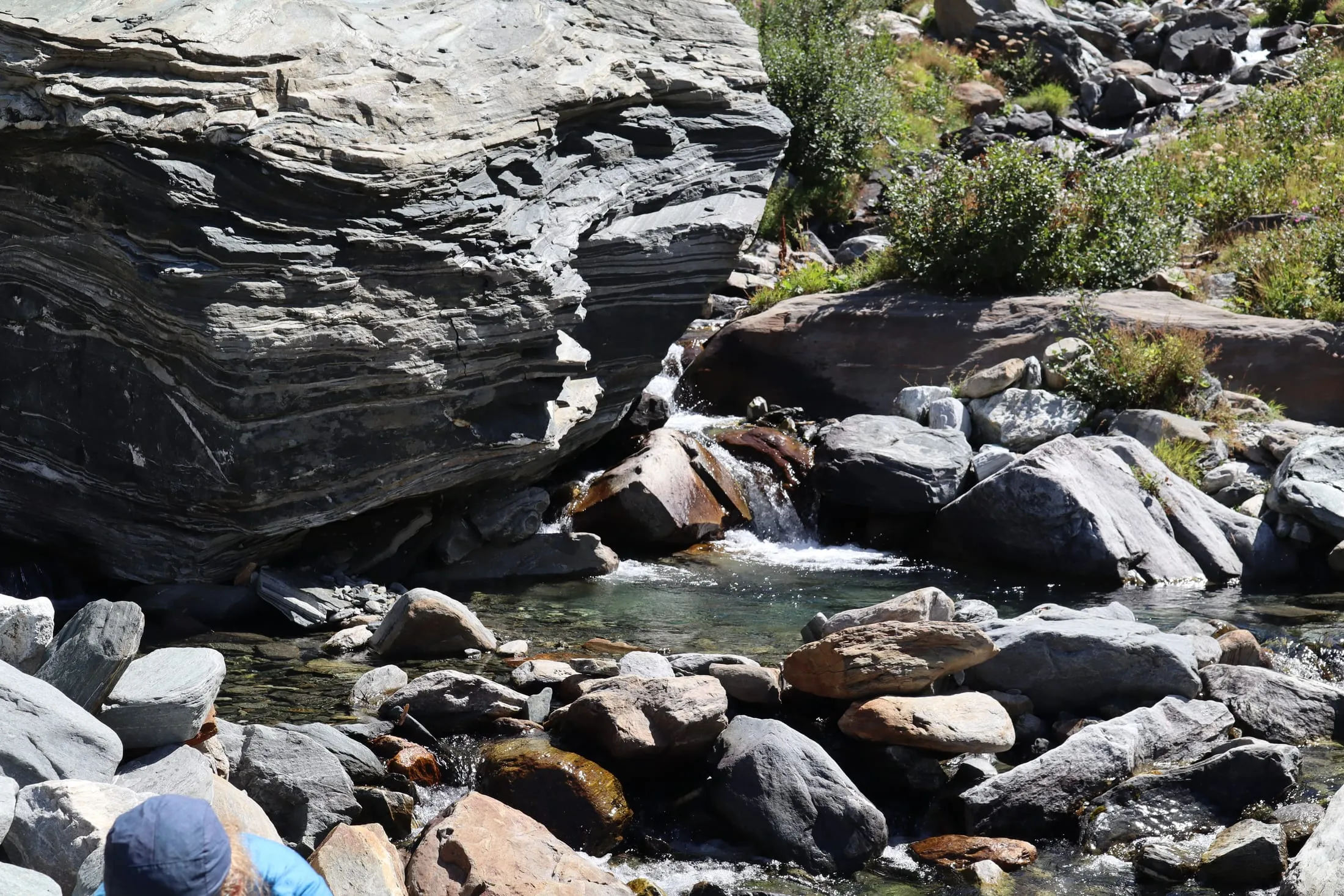 Cold pool below a small waterfall in folded rock.