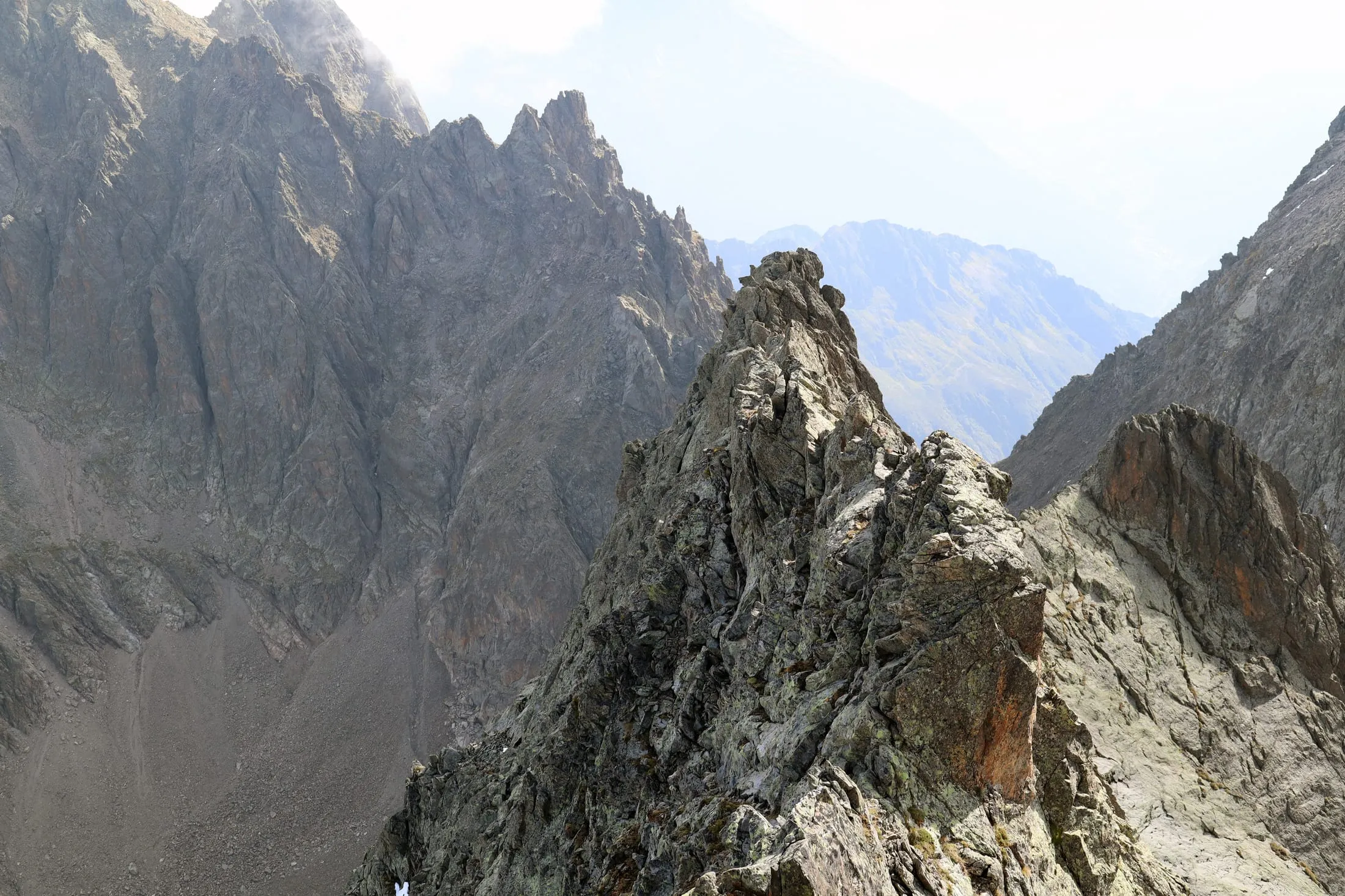 Mountaineer in crampons crossing a steep snowfield with an ice axe.