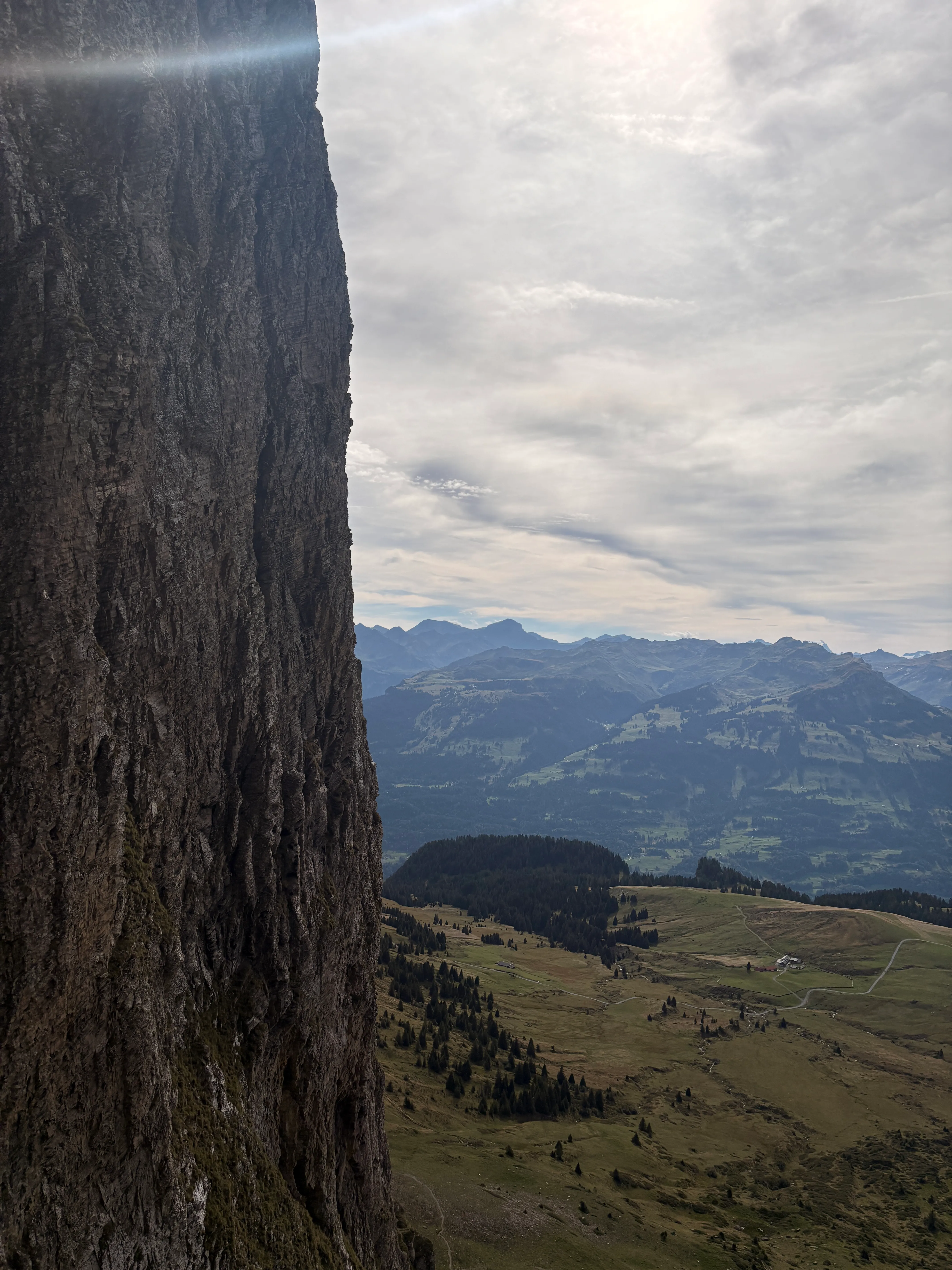 Traversing beneath a huge vertical rock wall, with the alp and Rhine valley far below.