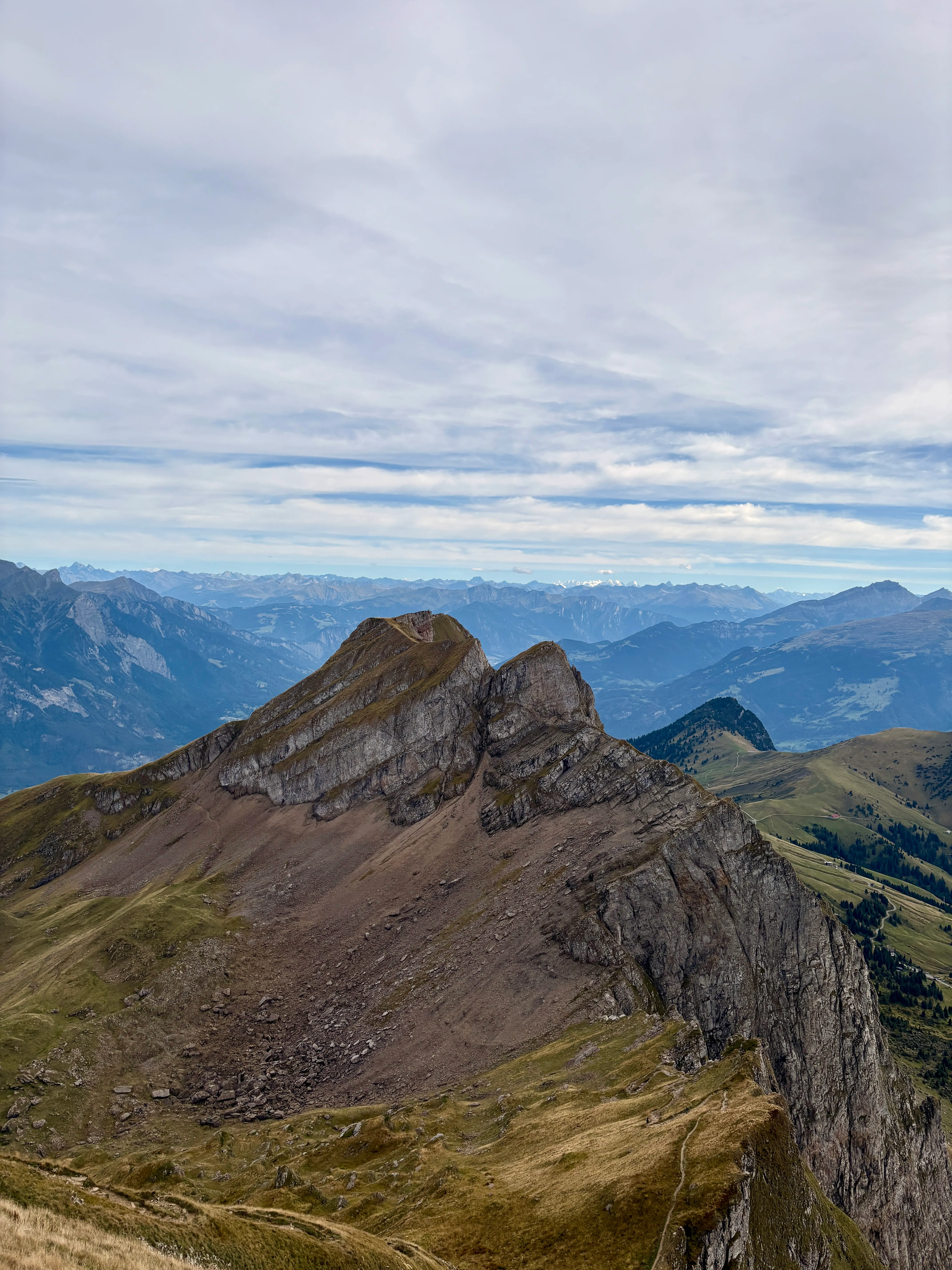 The layered summit ridge of the Alvier against endless mountain ranges stretching to the horizon.