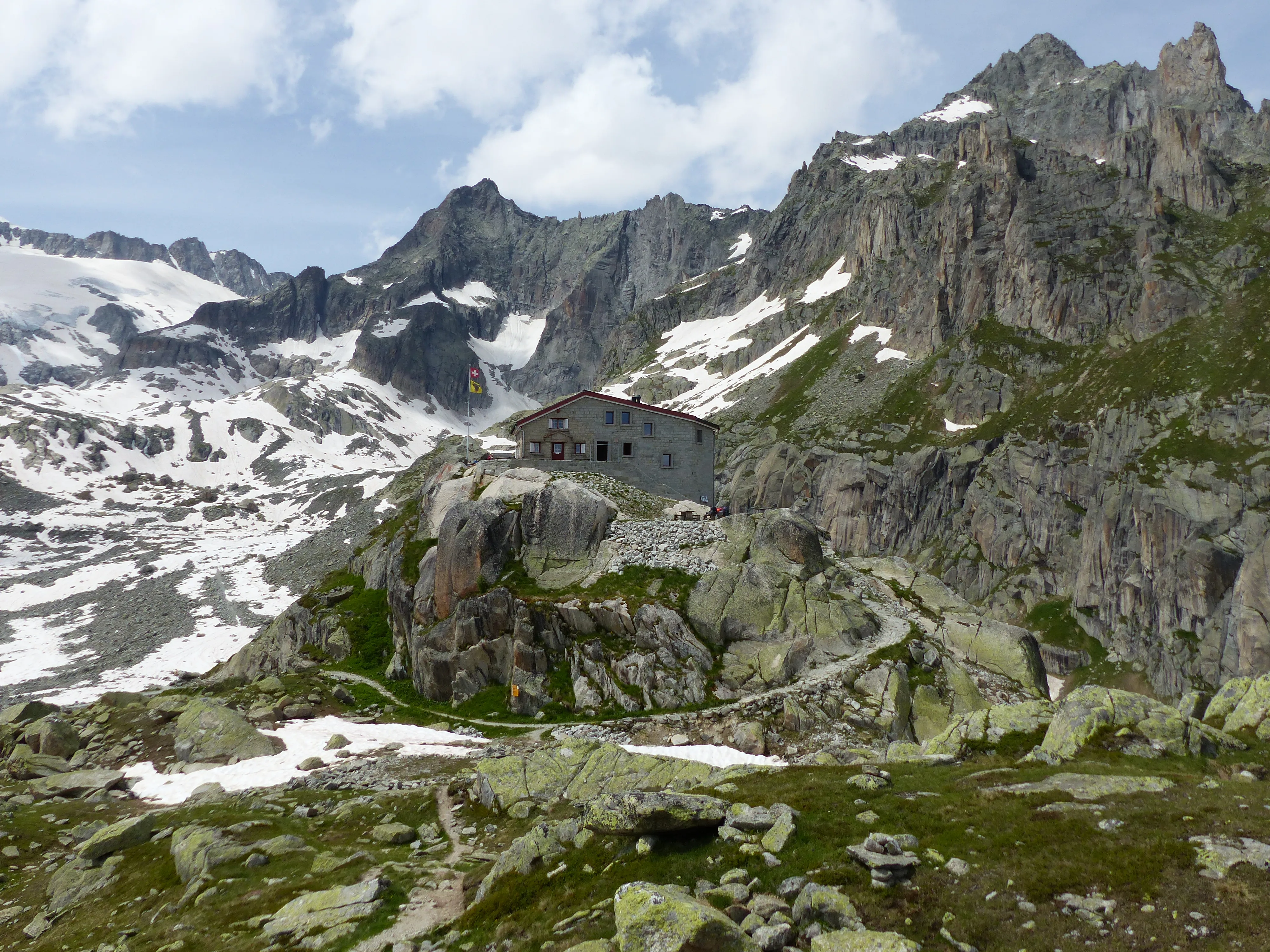 The Gletschhorn massif of Aar granite above the Albert Heim hut, in summer — the Strahlengrätli runs up the buttress below the peaks.