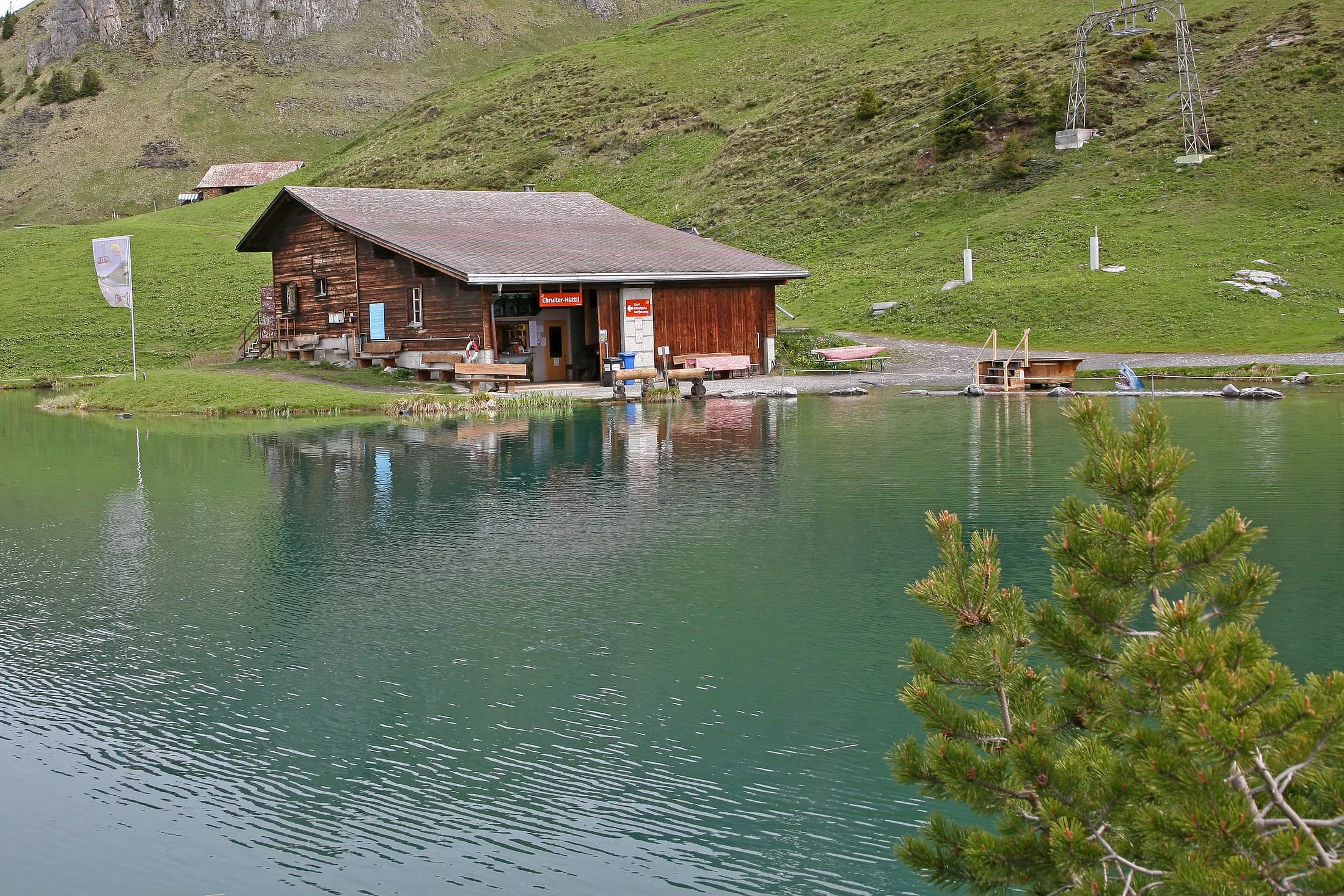 The heart-shaped Härzlisee mirrors the mountains at Brunni above Engelberg, with the small Chruiter-Hüttli on its shore.