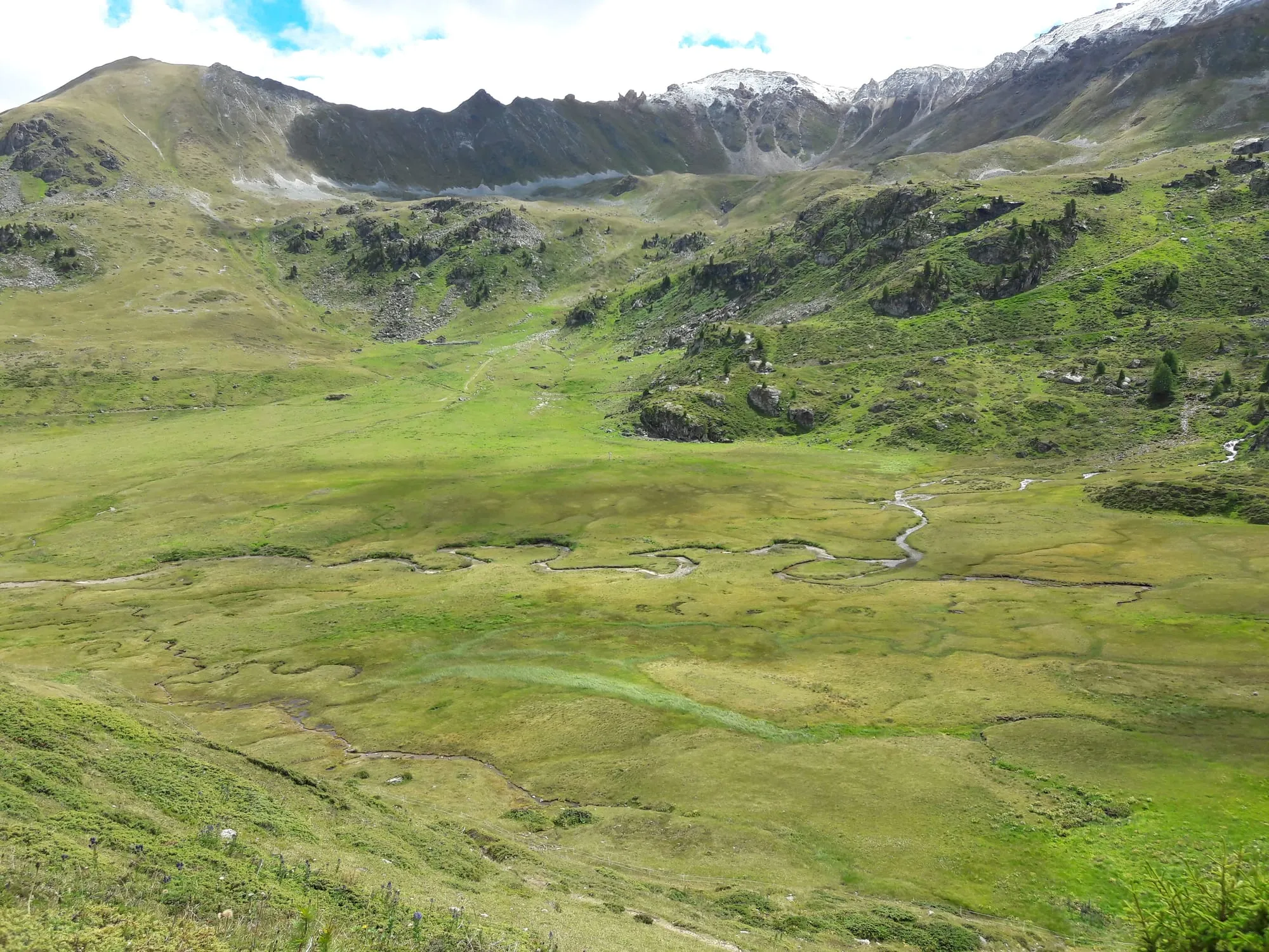 The alpine tarn L'Ar du Tsan resting in the protected wetlands of the Vallon de Réchy.