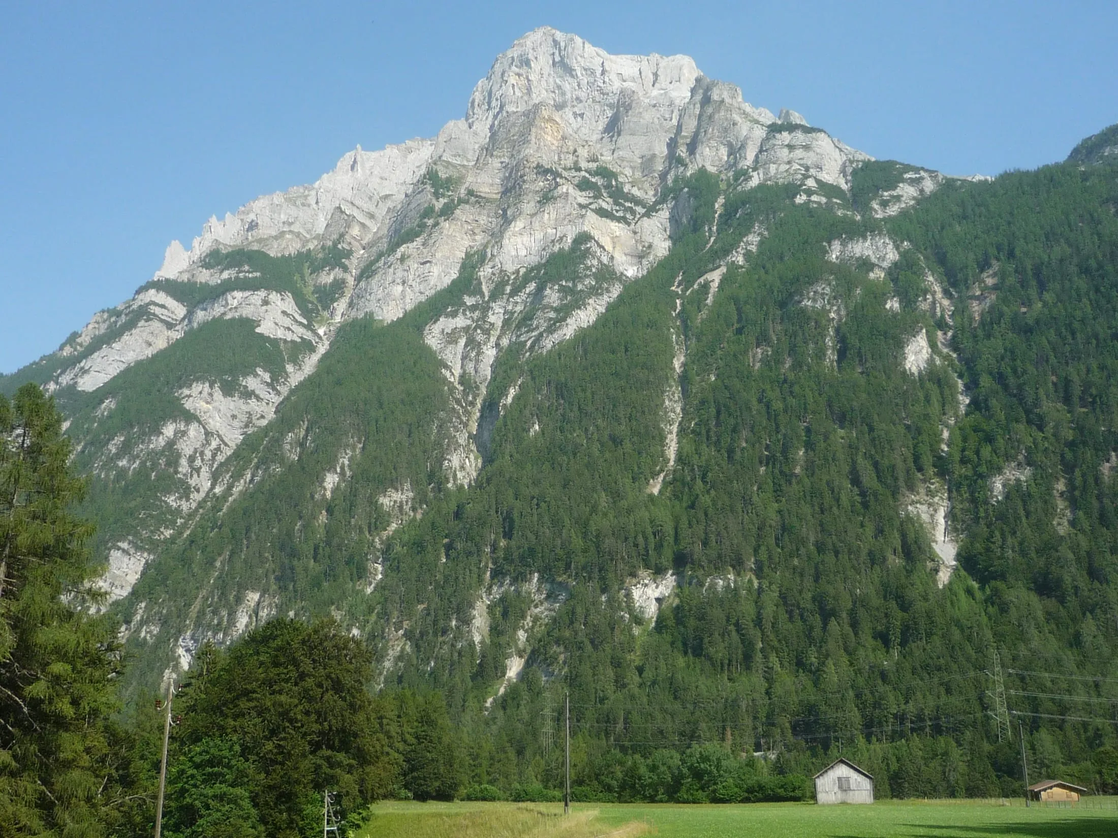 The Haldensteiner Calanda from Vättis, its pale rock face high above the forests of the Tamina valley.