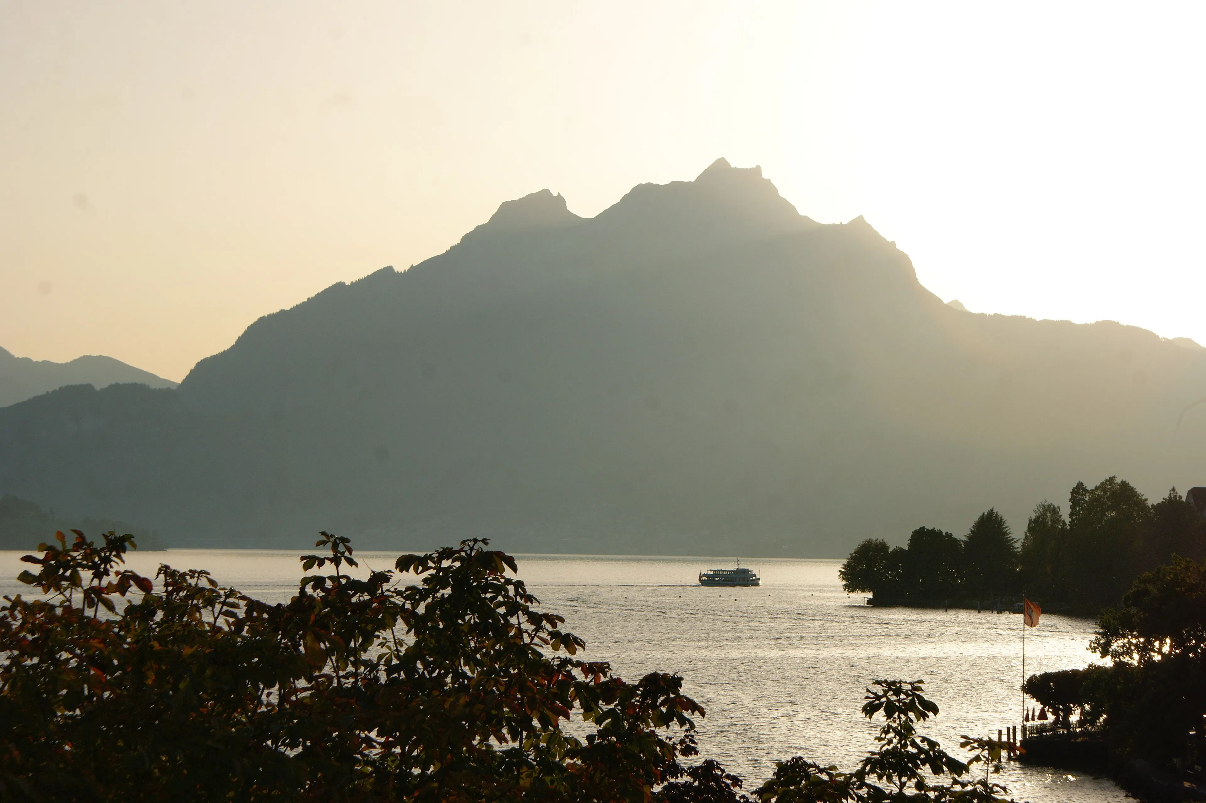 The Pilatus in silhouette above Lake Lucerne, backlit with a lake steamer.