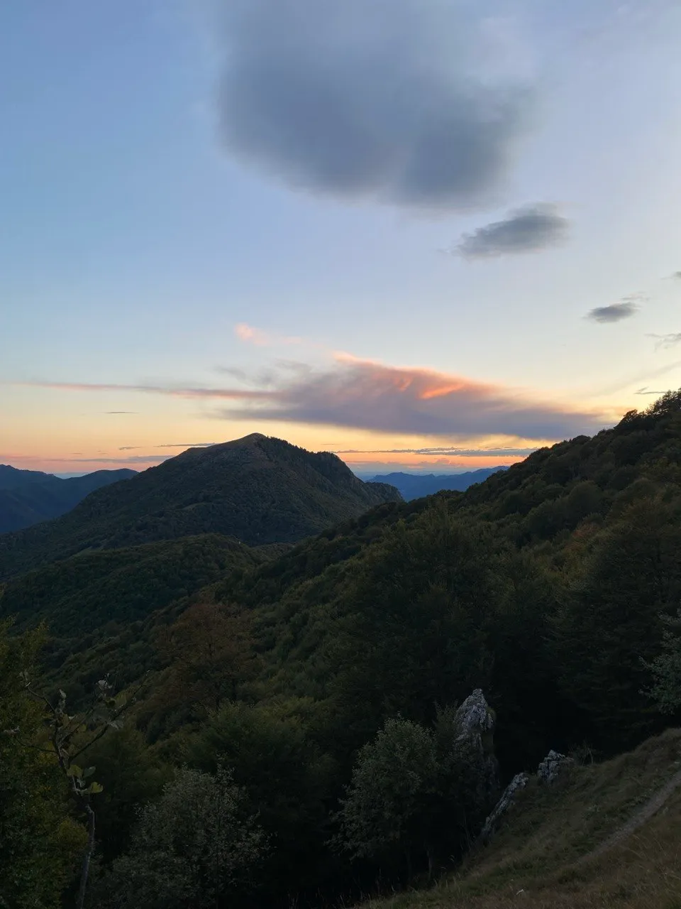 Evening light over the wooded ridges around Monte Boglia, a band of colour in the sunset above Lake Lugano.