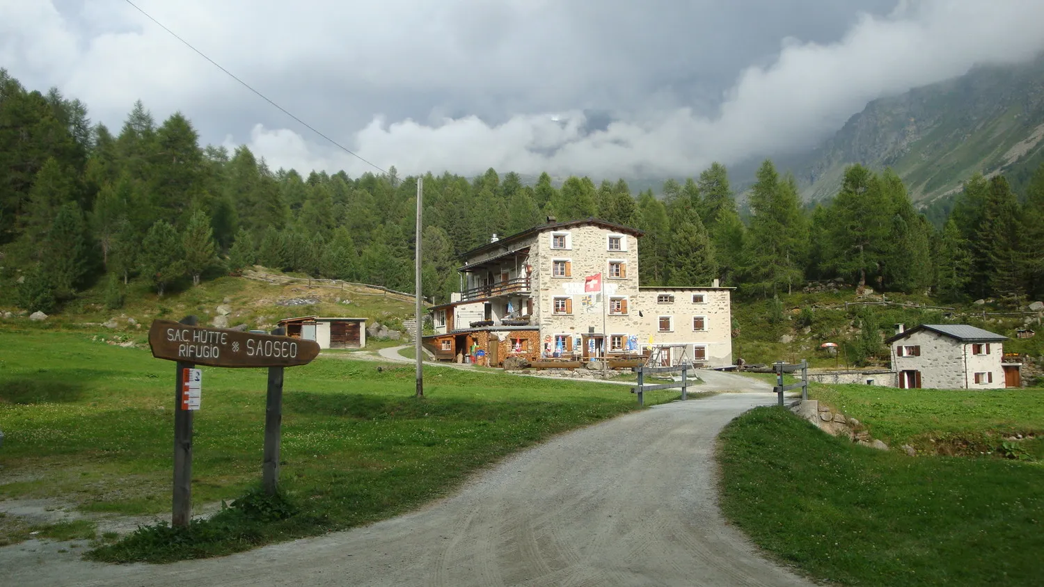 The Rifugio Saoseo in the Val di Campo near Poschiavo, surrounded by larch forest and summer meadows.