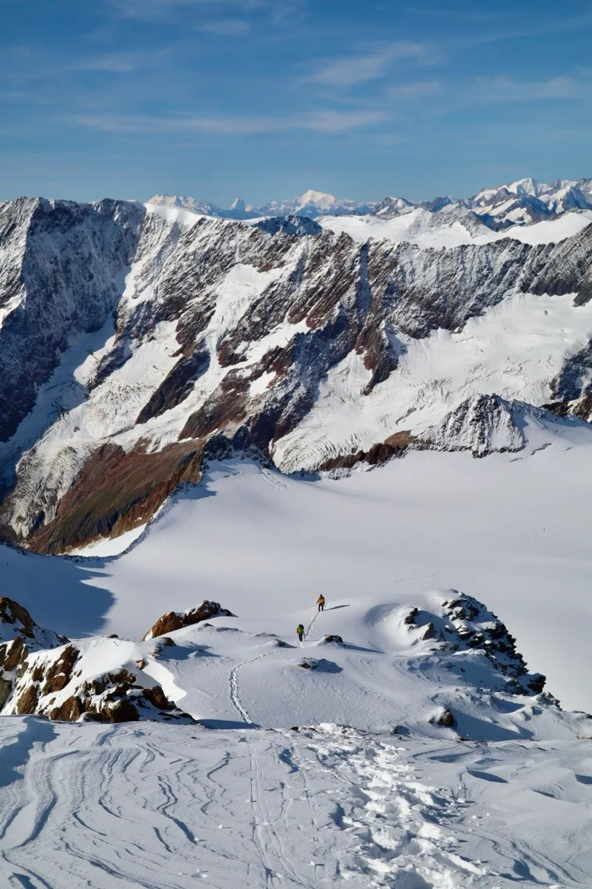 Sweeping glacier panorama from high up with distant ranges on the horizon.