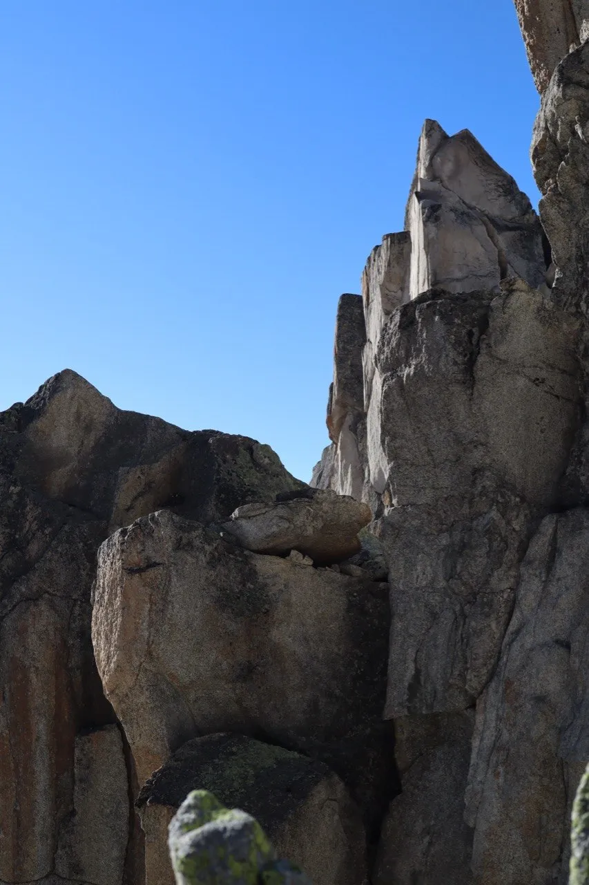 Jagged granite pinnacles rising into a clear blue sky.