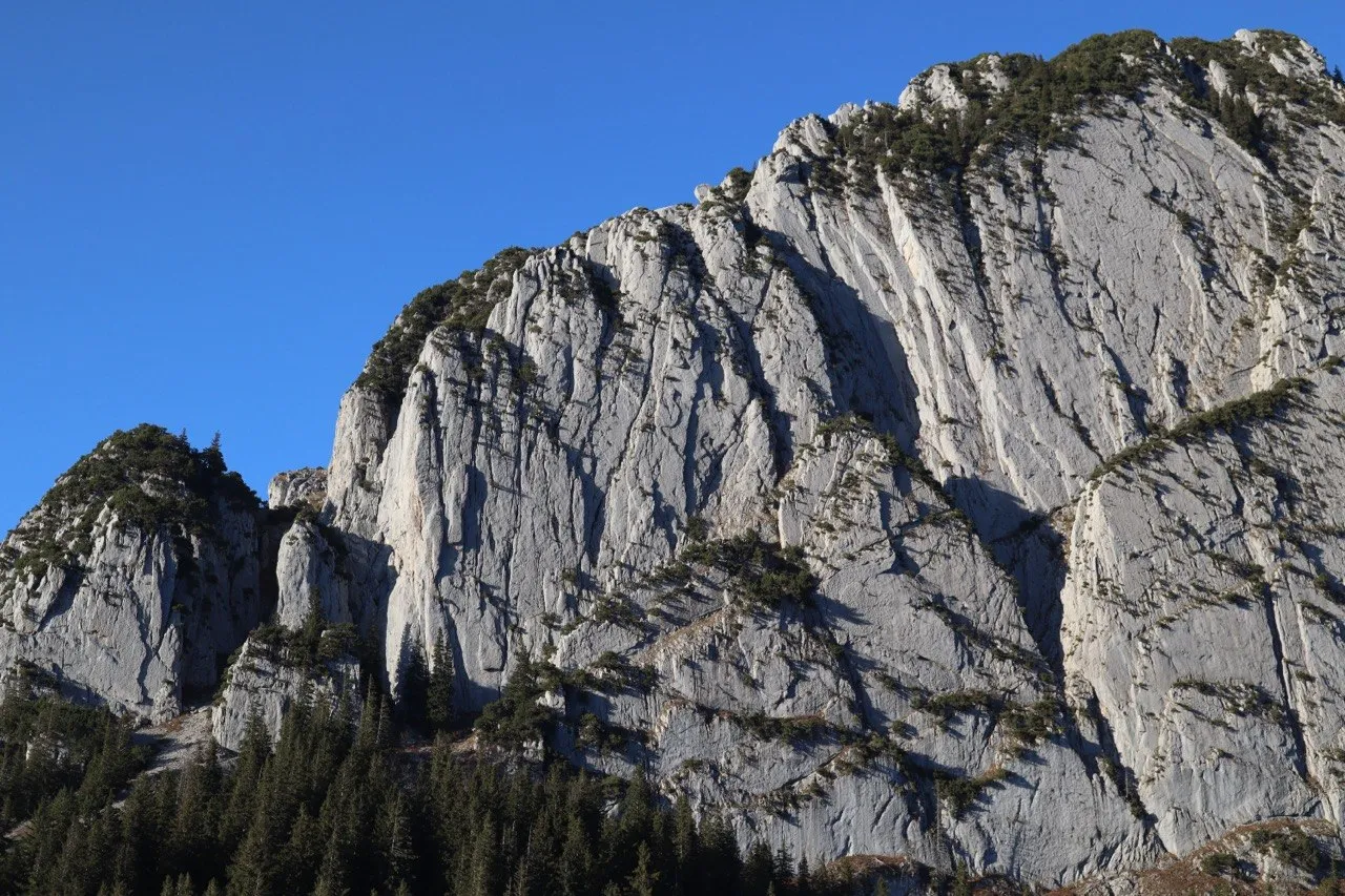 The steep grey limestone face of the Schafberg in the Alpstein against a blue sky.